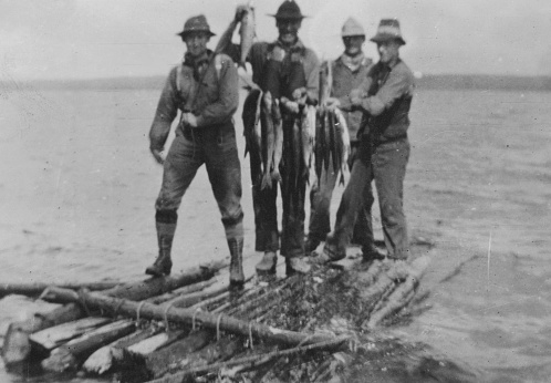 Buffalo Lake, Alberta, Canada - 1915. Group of men displaying the fish they caught that day for dinner at Buffalo Lake in Alberta, Canada.
