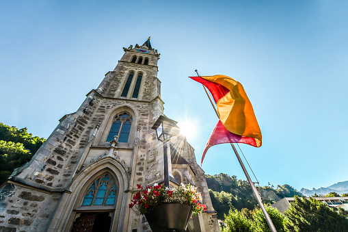 Flag Waving In The Wind Near St. Florin Cathedral In Vaduz, Liechtenstein