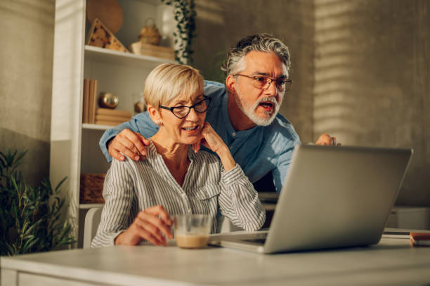 istock Senior couple using a laptop at home 1459774055