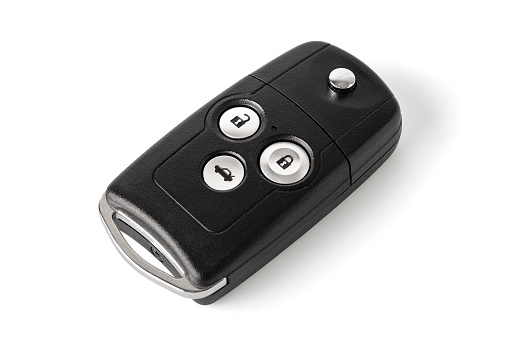 Car keychain with remote controlled alarm on a white background. Close-up