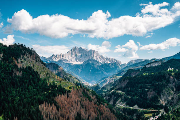 Italian Alps on a beautiful sunny summer day. Clouds on the blue sky.