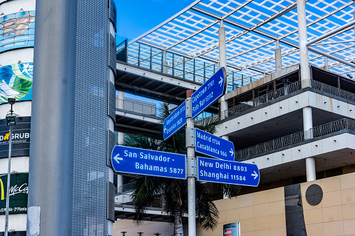 A sign outside a shopping centre in las Palmas, Gran Canaria, with directions and kilometres to Shanghai, New Delhi, The Bahamas and Capetown.