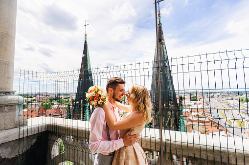happy couple embracing to each other on the balcony and with a view of the panorama of the city