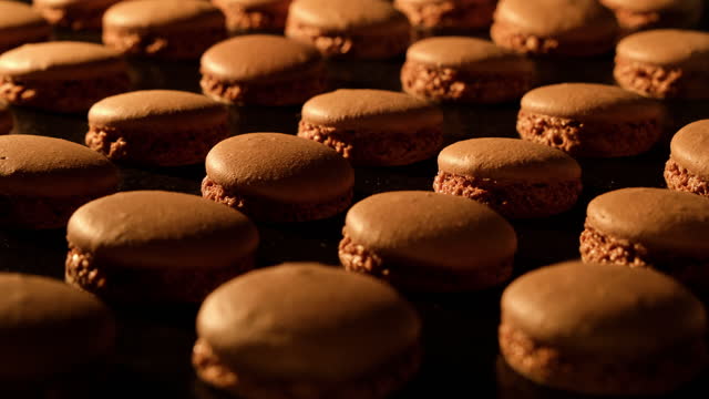 Baking chocolate macaroons in electric oven. Timelapse of growing macarons.