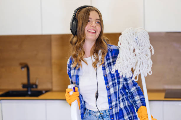 happy beautiful young woman, housewife in rubber gloves, headphones sings, dances, cleaning the floor in the kitchen. - cotton swab audio imagens e fotografias de stock