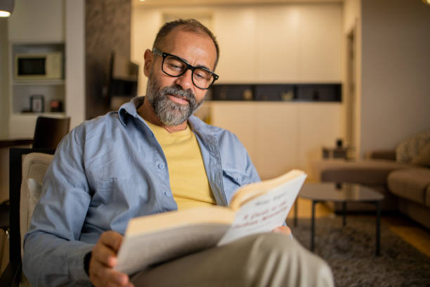 istock Mid adult man is reading a book 1459779853