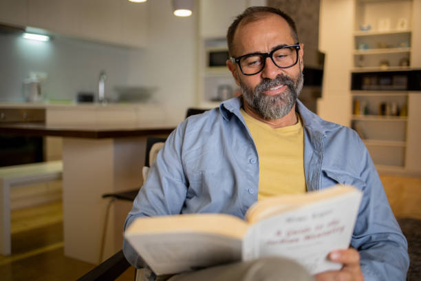 istock Happy mid adult man is reading a book 1459779854
