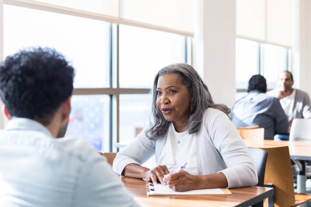 istock High school program director talks to young adult male 1459782816