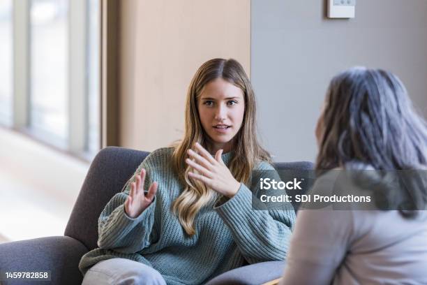 Young Adult University Student Talks With Her Peer Stock Photo - Download Image Now - Psychotherapy, Discussion, Mental Health Professional