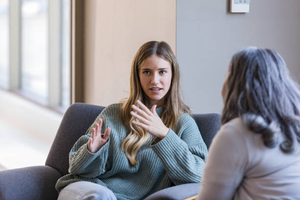 young adult university student talks with her peer - terapia alternativa imagens e fotografias de stock