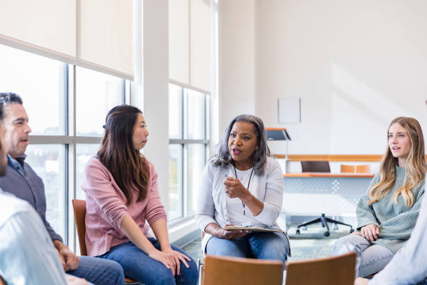 istock Mental health therapist talks to group member 1459782881