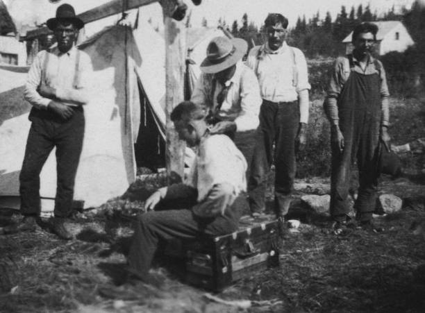 Man Getting a Hair Cut in a Camp at Pelican Narrows in Saskatchewan, Canada - 1919 Pelican Narrows, Saskatchewan, Canada - 1919. Man getting his hair cut in a camp at Pelican Narrows in Saskatchewan, Canada. 1910 1919 photos stock pictures, royalty-free photos & images