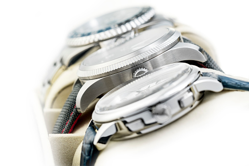 Three wrist watches in row. The first in foreground is a cronograph classic watch, the one in the middle is a pilot style and the last one in the background is a submarine watch.