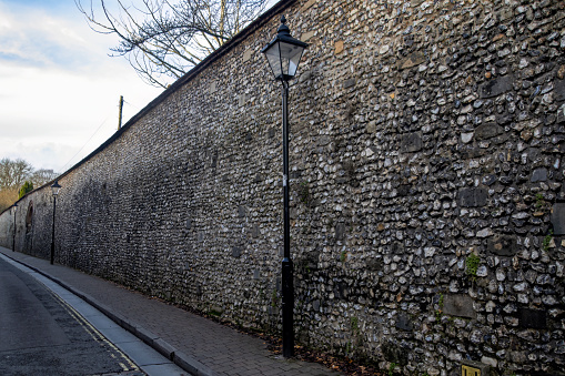 Street lamps and an old stone wall in Winchester, Hampshire, UK