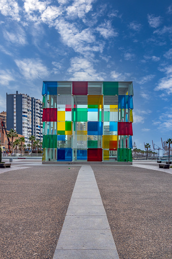 Centre Pompidou. Colorful glass cube in sunlight and amazing blue sky above, entrance to Centre Pompidou, located in renovated port area of Malaga