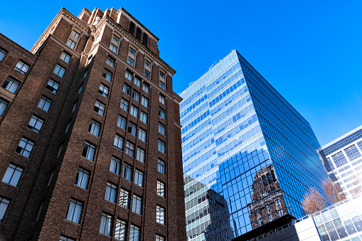 View looking up at buildings in downtown Houston, Texas; one a residential building, and the others commercial office towers.