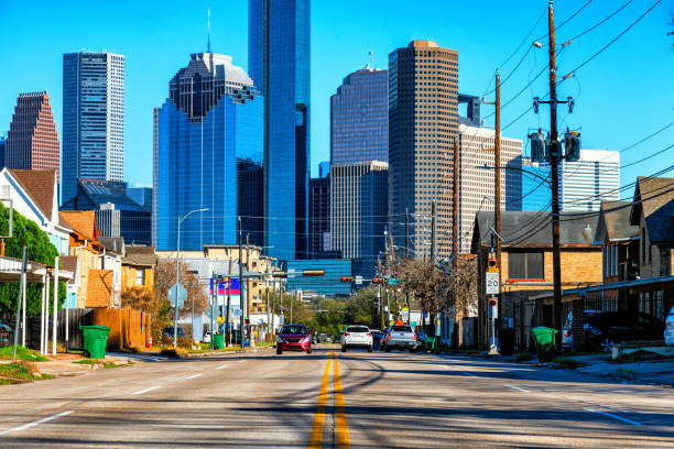 A city street in the Midtown neighborhood leading to the downtown Houston skyline.