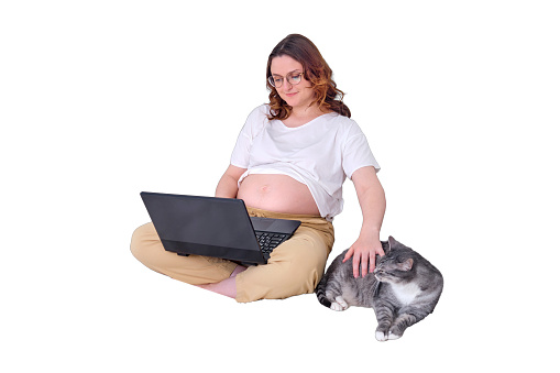 Workplace in a home bedroom with a computer and phone, a pet sitting on the bed and a pregnant woman working on a laptop, isolated on a white background