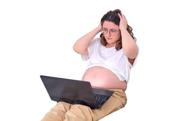 istock A pregnant woman holds her sore head with her hands, isolated on a white background. Problems and stress at online work from home during pregnancy 1459799773