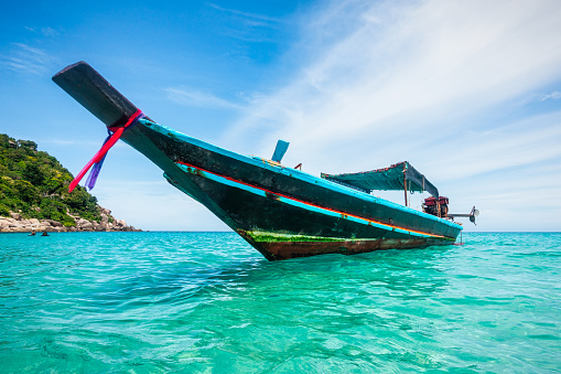 Thai traditional wooden longtail boat at tropical beach in Thailand