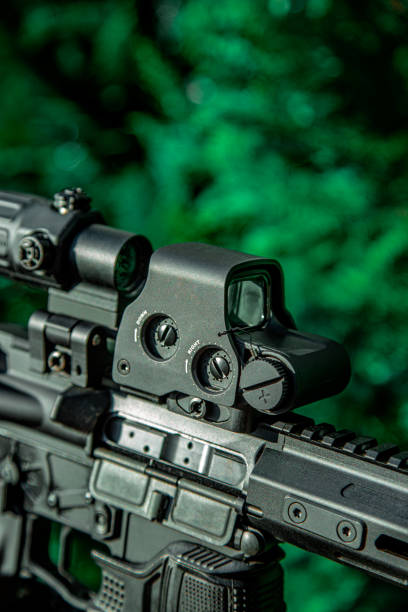 istock Modern automatic rifle. Weapons for police, special forces and the army. A carbine with optical sights on a green fir background. 1459808580