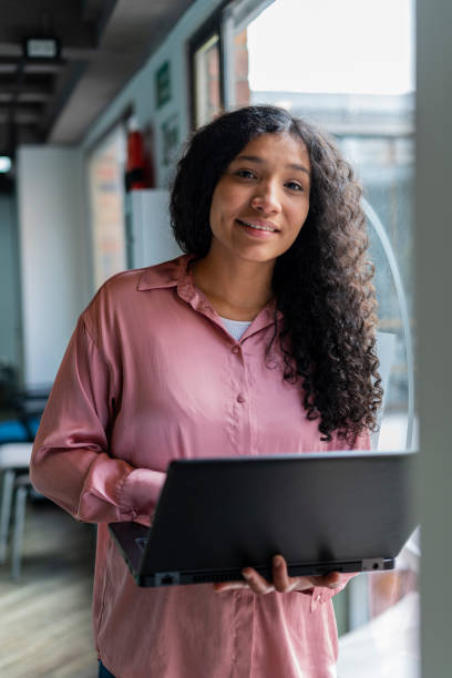 istock afro latin woman are inside the office where they work with their computer in hand working 1459812251