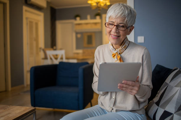 istock Happy senior woman using digital tablet 1459828100