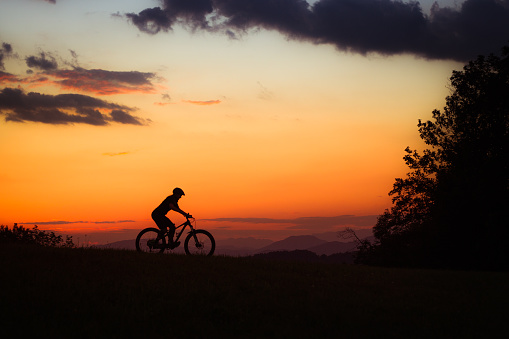 Female cyclist silhouette against sunset