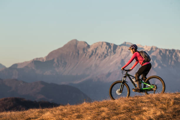 istock Female mountain biker descending from a mountain on her bicycle 1459828284