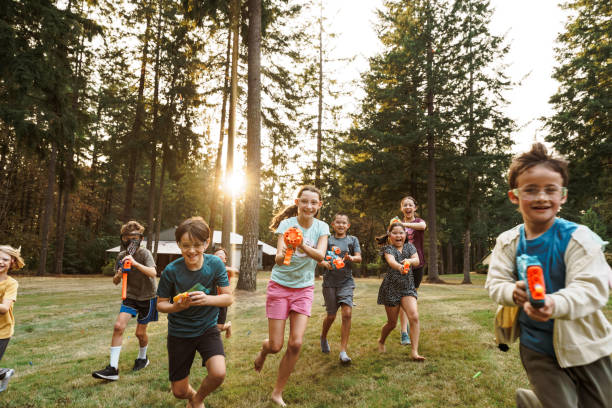 Group of kids having a fun nerf gun battle outside