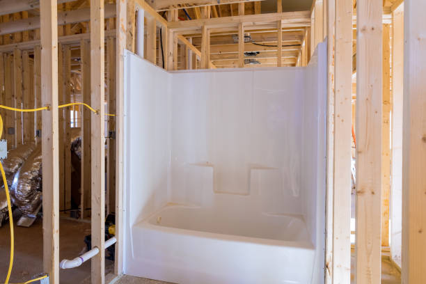 A unfinished bathroom under construction home with installed acrylic bathtub in new house stock photo