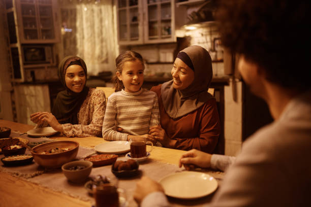 istock Happy Muslim multigeneration family talking during dinner at dining table. 1459846249