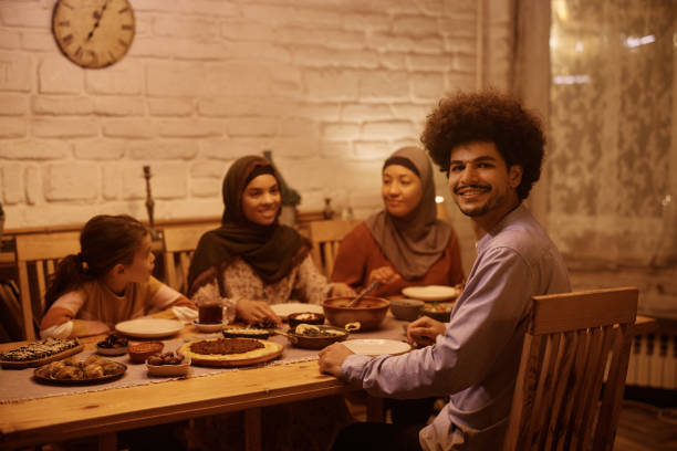 istock Happy Muslim man and his extended family having dinner at dining table. 1459846288