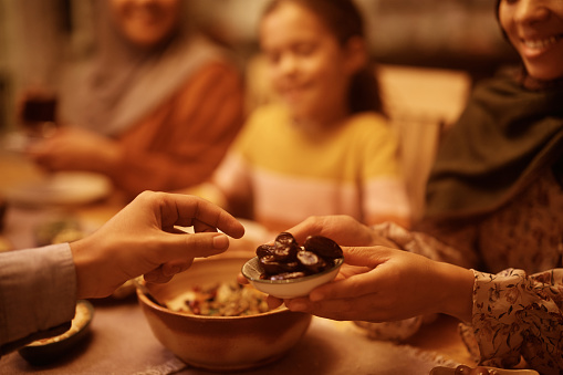 Primer plano de una pareja musulmana comiendo sésamo de postre en la mesa del comedor. photo