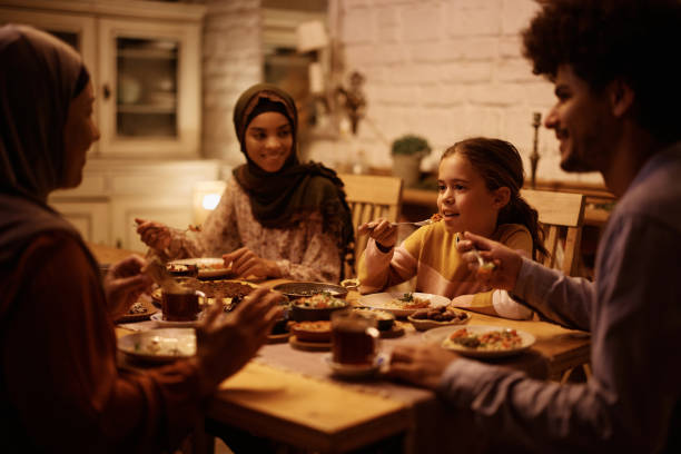 istock Multigeneration Muslim family eating dinner together at dining table. 1459846393