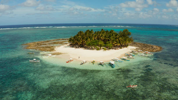 istock Tropical Guyam Island with a sandy beach and tourists. 1459849269