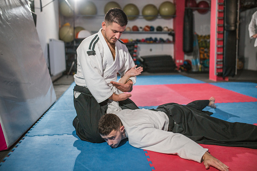 Two young samurai train and practice aikido skills in a gym