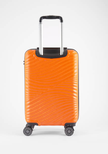 valigia arancione su bianco - valigia a rotelle foto e immagini stock