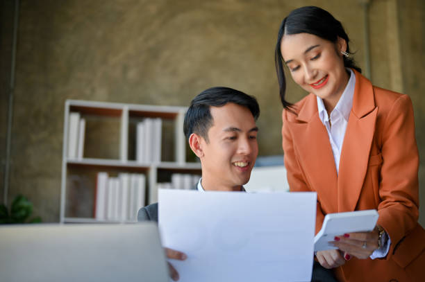 istock Smart Asian male CEO working with his beautiful assistant in the office. 1459857043