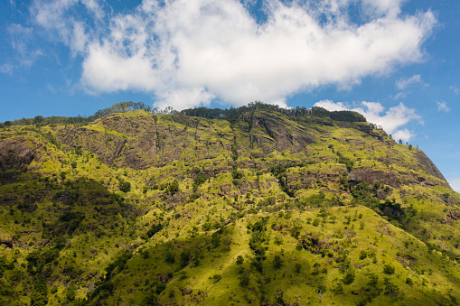 Aerial drone of slopes of mountains and hills with green vegetation and trees. Mountain landscape in Sri Lanka.
