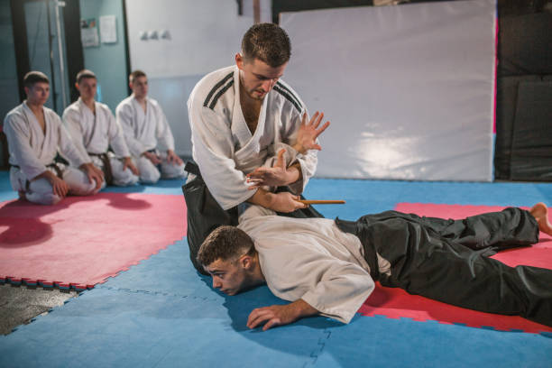 istock An aikido trainer demonstrates a self-defense technique to a group of fighters 1459858024