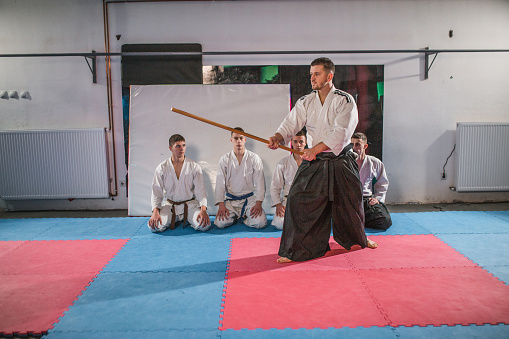 A person practicing aikido martial art on a black background.