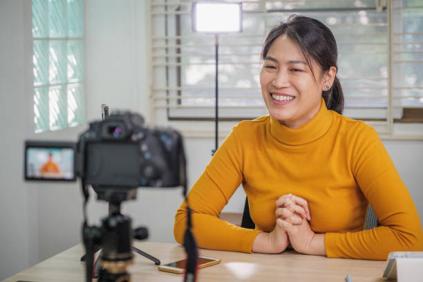istock Asian woman vlogger live streaming from her office using camera tutorial video to social network by internet at home 1459867243