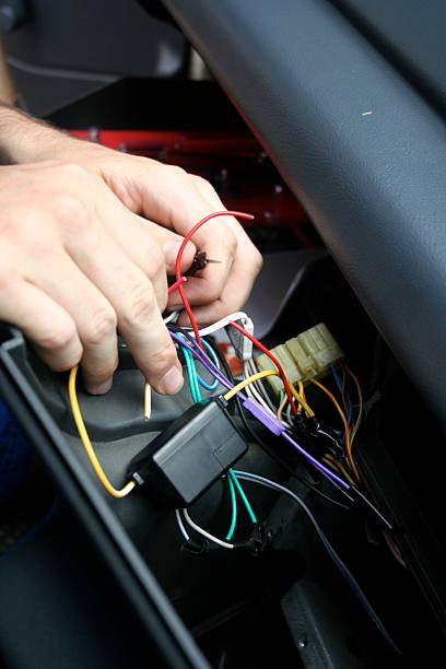 istock Hands fixing wires in the interior of a car 145986893