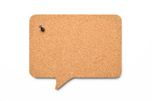 Close-up of black thumbtack on speech bubble made of cork, isolated on white with clipping path.
