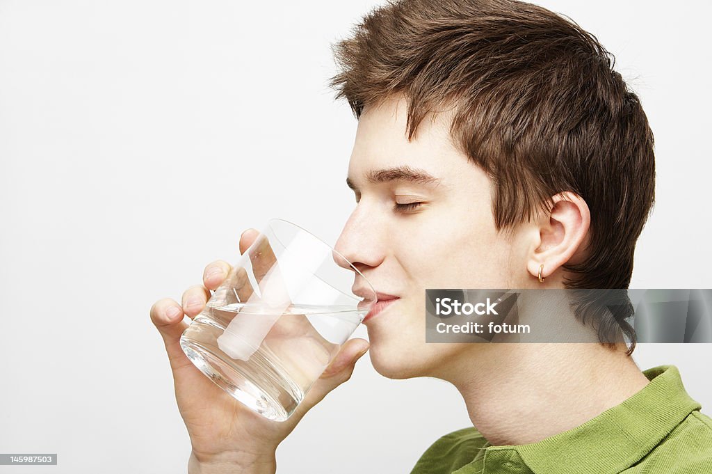 young man is drinking mineral water young handsome man is drinking mineral water Adult Stock Photo