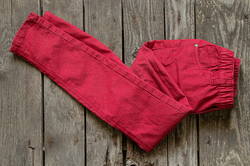 new red pants womens on a wooden table