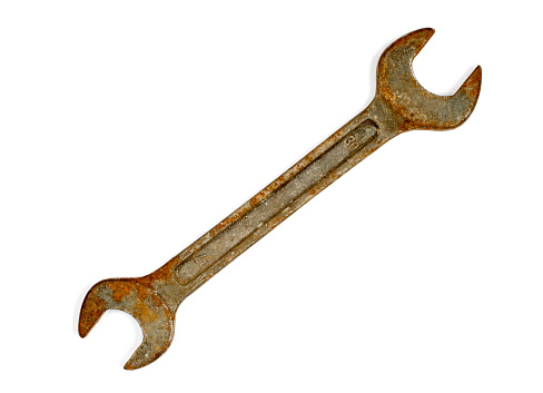 Rusty wrench on a white background. An old wrench close-up.