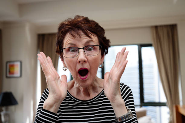 istock Senior woman indoors getting a surprise 1459881973