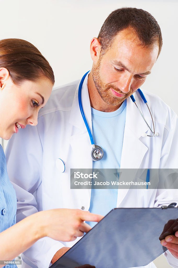Masculino médico examinar um relatório médico com a enfermeira - Royalty-free Adulto Foto de stock